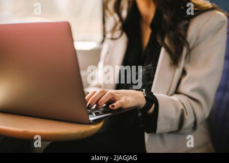 Midsection of businesswoman using laptop while commuting in train Stock Photo