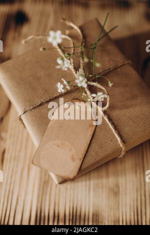 festively wrapped gift in kraft paper with a tag for wishes Stock Photo