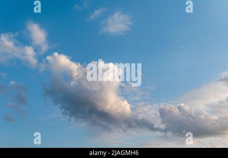 Fluffy clouds in spring blue sky. Sunlight on white clouds Stock Photo