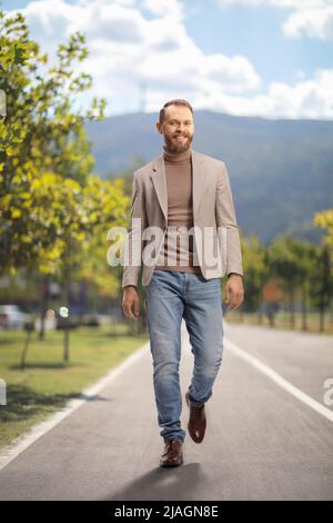 Young man walking on a pedestrian lane and smiling Stock Photo