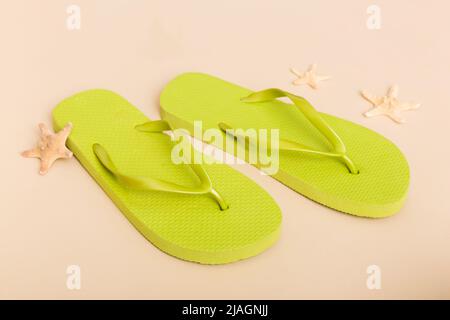 Beach accessories. Flip flops and starfish on colored background. Top view Mock up with copy space. Stock Photo