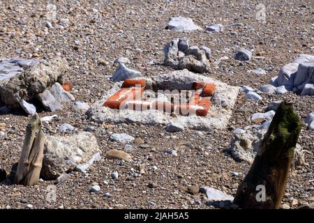A very old sewer manhole minus its cover, built from old bricks and long since abandoned and left to slowly be eroded away buy the tidal actions. Stock Photo