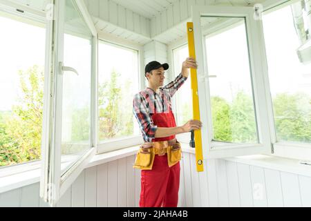 Man measuring window prior to installation of roller shutter outdoors. Stock Photo