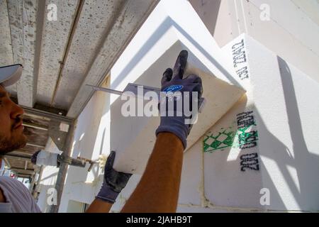 Construction workers insulates house facade Stock Photo