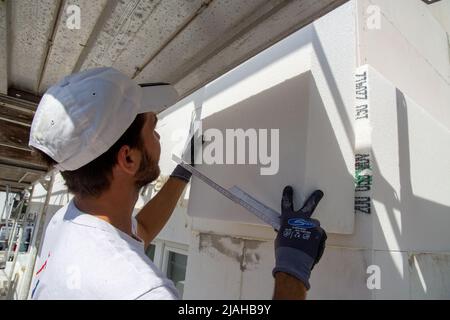Construction workers insulates house facade Stock Photo