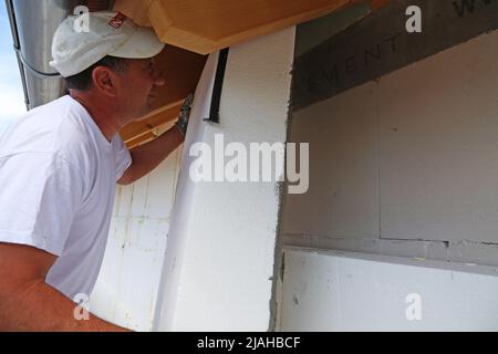 Construction workers insulates house facade Stock Photo