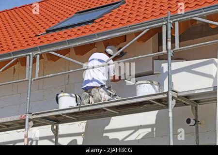 Construction workers insulates house facade Stock Photo