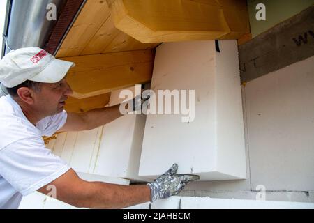 Construction workers insulates house facade Stock Photo