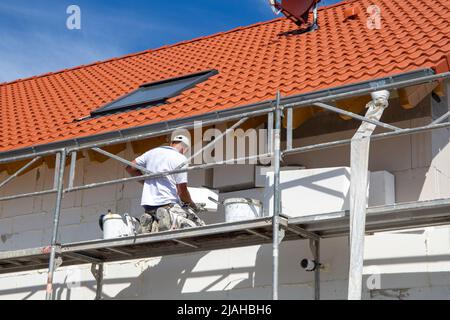 Construction workers insulates house facade Stock Photo