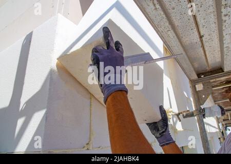 Construction workers insulates house facade Stock Photo