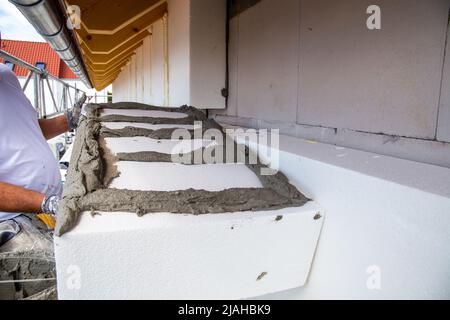 Construction workers insulates house facade Stock Photo