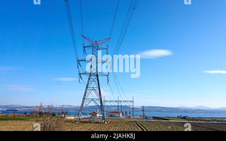High voltage towers with hanging power lines and power station Stock Photo
