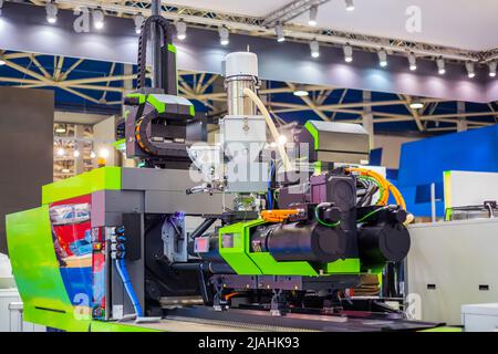 Automatic plastic injection molding machine during work at exhibition Stock Photo