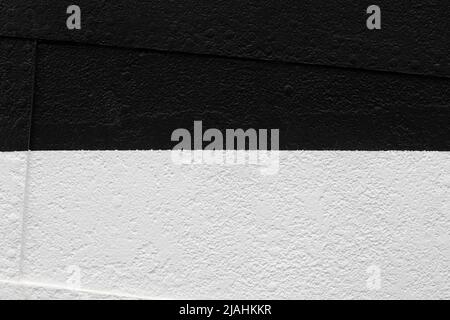 Uneven and bumpy wall painted in black and white. Front view. High resolution full frame textured background. Copy space. Stock Photo