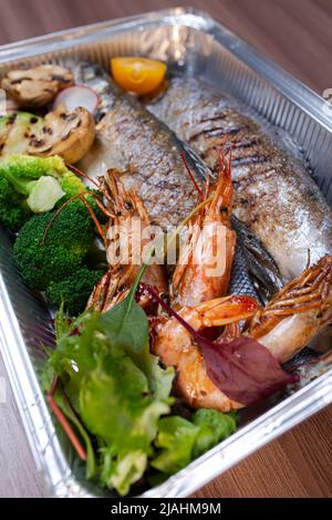 assorted fish and shrimp in a metal box. Stock Photo