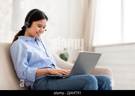 Positive japanese woman freelancer working from home, using gadgets Stock  Photo by Prostock-studio