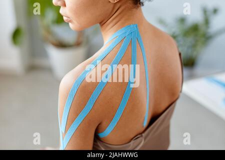 Close up of young black woman with physio tape on shoulder in rehabilitation therapy, copy space Stock Photo