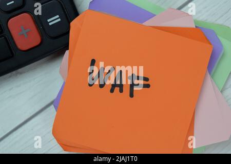 Concept of WAF - Web Application Firewall write on sticky notes isolated on Wooden Table. Stock Photo
