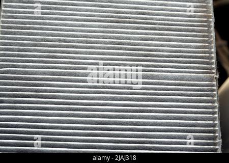 A closeup of an old dirty used car AC air conditioning filter full of dust removed from the vehicle to be replaced with a new one, cabin air carbon fi Stock Photo