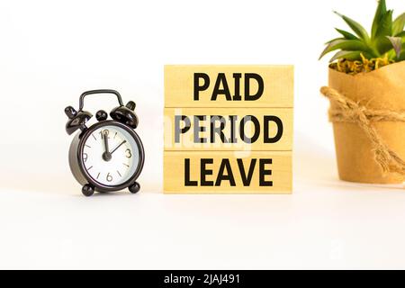 Paid period leave symbol. Concept words Paid period leave on wooden blocks. Black alarm clock. Beautiful white table white background. Business medica Stock Photo