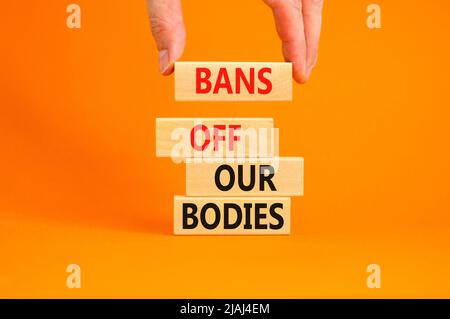 Bans off our bodies symbol. Concept words Bans off our bodies on wooden blocks on beautiful orange table orange background. Women rights concept. Busi Stock Photo