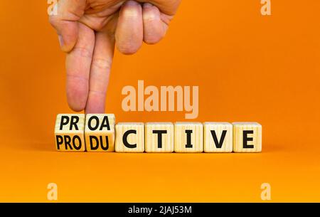 Proactive and productive symbol. Businessman turns cubes and changes the concept word Productive to Proactive. Beautiful orange background. Business p Stock Photo