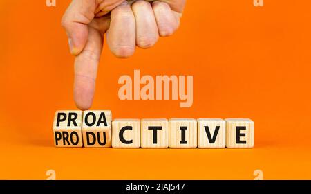 Proactive and productive symbol. Businessman turns cubes and changes the concept word Productive to Proactive. Beautiful orange background. Business p Stock Photo