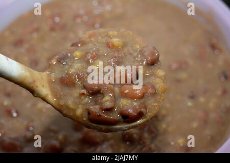 A ladle full of Egyptian fava beans which is the main dish and sandwich in the breakfast in Egypt, cooked with crushed bean, yellow lentils and wheat, Stock Photo