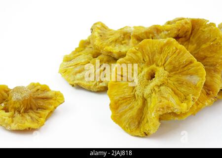 Natural dried pineapple on a white background. Dried pineapple without sugar cut into rings. Candied tropical fruits. Stock Photo