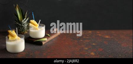 Tasty Pina Colada cocktails on dark background with space for text Stock Photo