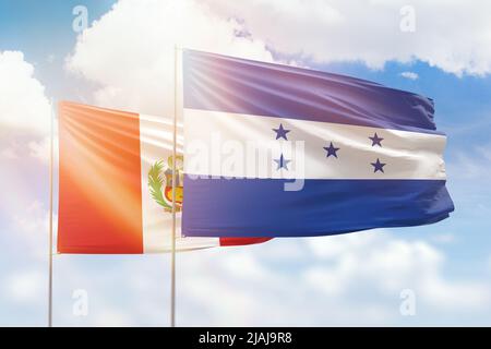 Sunny blue sky and flags of honduras and peru Stock Photo