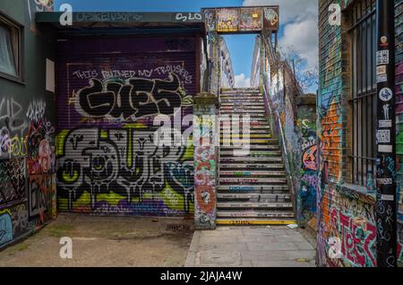 A footbridge covered with grafitti and street art over the railway on Cheshire Street near Brick Lane in the East End of London, UK. Stock Photo