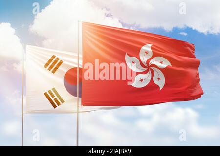 Sunny blue sky and flags of hong kong and south korea Stock Photo