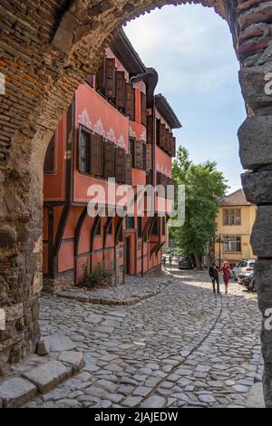 Hisar Kapia - A veiw of a pair walking by the paved street in old town of Plovdiv framed with the acity ncient gate Stock Photo