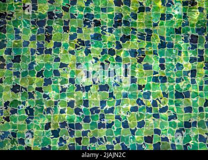 Water level ripples over decorative tiles at the bottom of the swimming pool Stock Photo