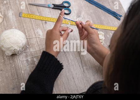 detail of hands knitting with wool and crochet, art and occupation, manual work place Stock Photo