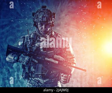 Soldier armed with sevice rifle, standing in the rain. Stock Photo