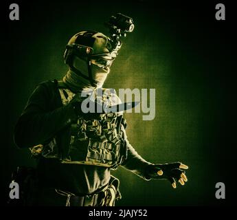 Commando fighter wearing a helmet with night vision, sneaking in the ...