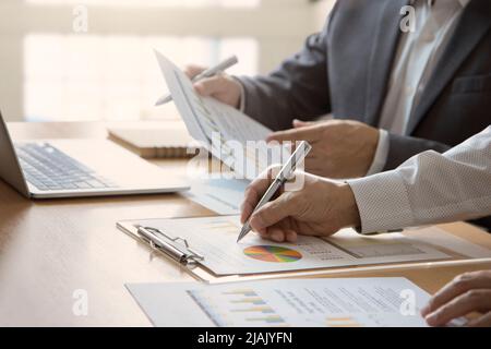 Businessmen or analysts with laptop computer reviewing a business information on a return on investment Stock Photo