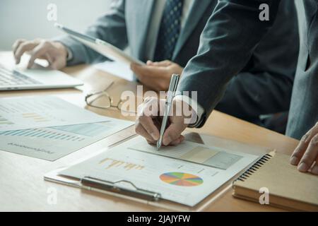 Businessmen or analysts with laptop and tablet reviewing a business information on a return on investment Stock Photo