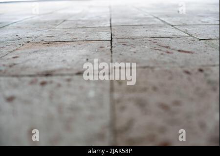 Close-up of the gray stone surface in a receding perspective. Exterior wall of building or road covered with rectangular stone slabs.  Selective focus Stock Photo