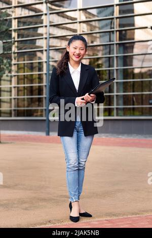 smiling asian business woman in financial district Stock Photo