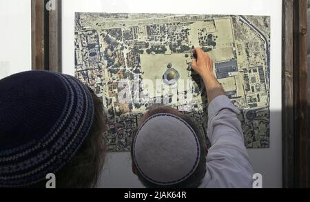 JERUSALEM, ISRAEL - MAY 29: Ultra-nationalist Israelis look at an aerial photograph featuring the complex of the Dome of the Rock before visiting the Temple Mount known to Muslims as the Haram esh-Sharif (Noble Sanctuary) during the Israeli holiday 'Jerusalem Day' ahead of the Jewish nationalist 'Flag march' in the old city on May 29, 2022 in Jerusalem, Israel. The Jerusalem Day Flag March marks the anniversary of the unification of the Old City and East Jerusalem in 1967. Stock Photo