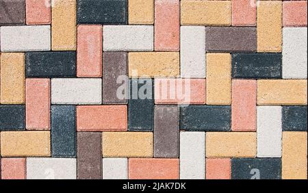 Sidewalk is lined with multi-colored road tiles. View from above. Stock Photo