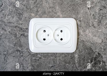 Detail of a double power European electric outlet on tiled wall Stock Photo