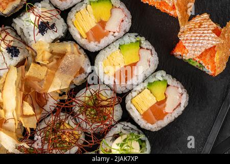 Sushi set of various products on a black stone plate Stock Photo