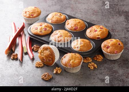Close-up of muffins with walnuts and rhubarb in a baking dish on the table. horizontal Stock Photo