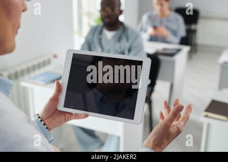 Close-up of female physician using digital tablet while speaking at conference for students Stock Photo