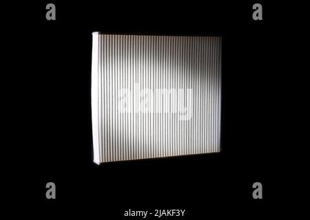 White cabin filter for cleaning the air in the car interior. Automotive spare part on a black background. Stock Photo