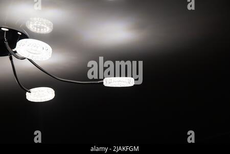 Modern LED chandelier on the ceiling of the house. Lighting with diodes Stock Photo